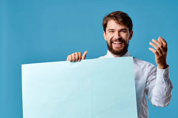 Vrolijke man met blauwe mockup poster teken kopie-ruimte blauwe achtergrond — Stockfoto