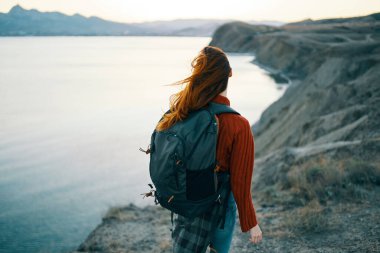 Kadın turist sırt çantası dağlar okyanus manzarası