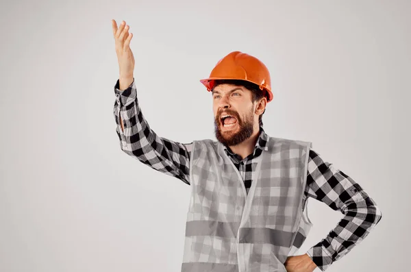 Männlicher Arbeiter orangefarbene Helmbaupläne Professioneller heller Hintergrund — Stockfoto