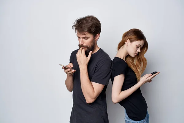 Fröhliches junges Paar in schwarzen T-Shirts telefoniert Spaß zusammen Freundschaft isoliert Hintergrund — Stockfoto
