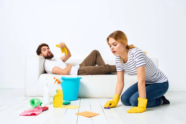 Married couple near the sofa cleaning of the apartment light background — Stock Photo, Image