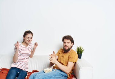 Genç bir çift kanepede oturup film izleyecek.