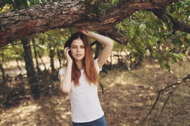 Güzel bayan dışarıda, ağacın yanında. Güneş özgürlüğü yolculuğu.