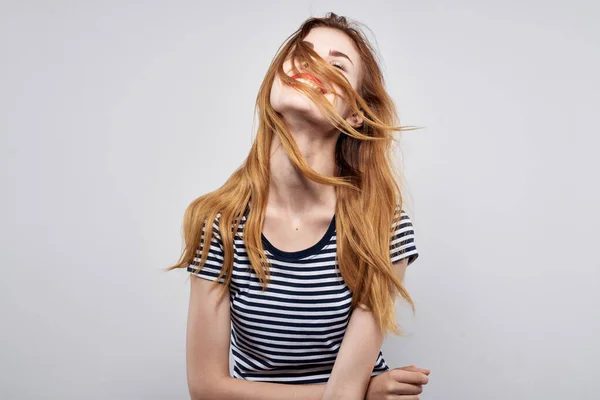 Fröhliche Frau in einem gestreiften T-Shirt Geste mit seinen Händen hellen Hintergrund — Stockfoto