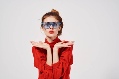 Seçkin arka plan pozu veren moda mavi gözlükleri olan kadın.