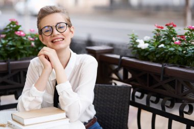 Elinde kitap olan bir öğrenci temiz hava eğitiminde yürüyor.