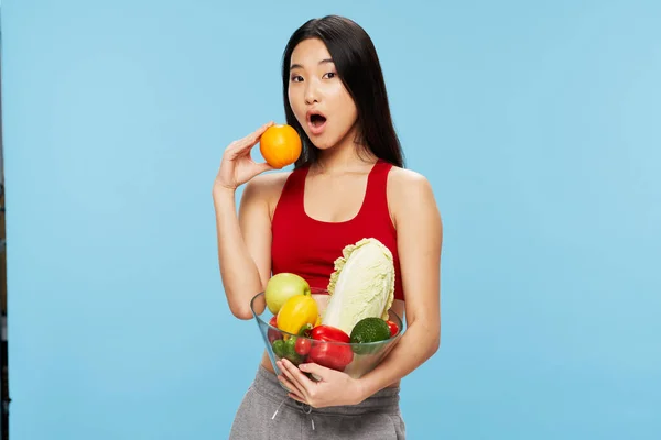 Diät schlanke Frau mit Gemüse auf blauem Hintergrund asiatische Aussehen Modell — Stockfoto