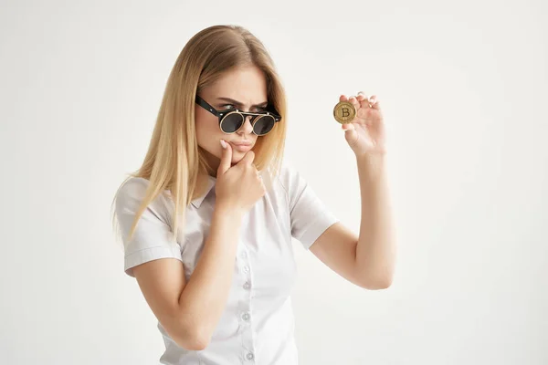 Бодрая женщина солнцезащитные очки Bitcoin криптовалюта в руках светлый фон — стоковое фото