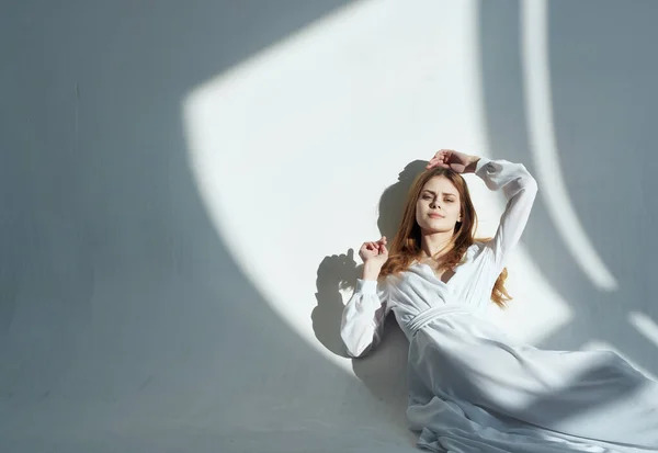 Mulher bonita em vestido branco posando glamour luz fundo — Fotografia de Stock