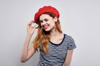 Neşeli bir kadın moda pozu veriyor. Çekici görünüyor. Kırmızı küpeler.