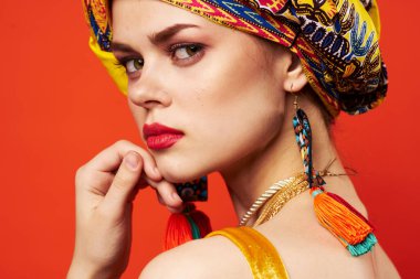 Neşeli kadın, çok renkli şal, etnik köken, Afrikalı tarzı, kırmızı arka plan.