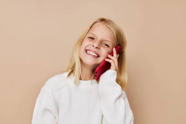 Positivo niña comunicación teléfono inteligente entretenimiento posando estudio —  Fotos de Stock
