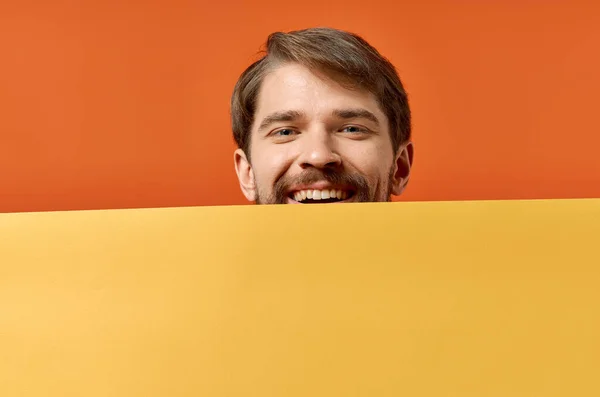 Hombre Emotivo Sosteniendo Una Pancarta Amarilla Sobre Fondo Naranja Foto — Foto de Stock
