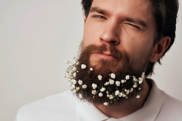 man in a white shirt with  flowers in a beard