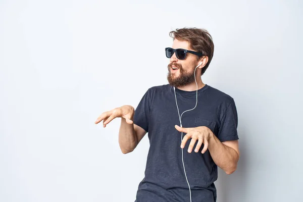 Vrolijke man hoofdtelefoon zonnebril muziek dans leuk licht achtergrond — Stockfoto