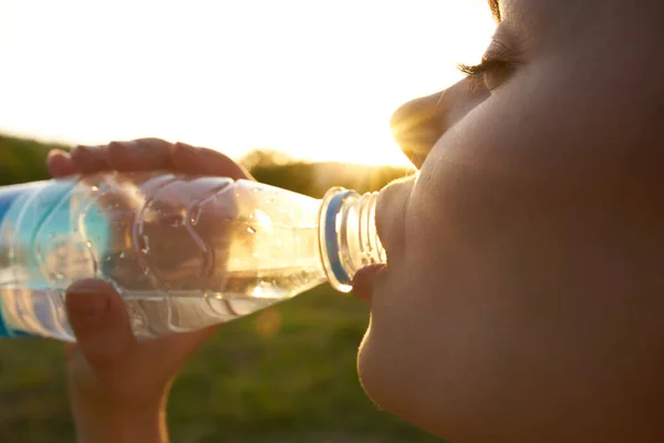 Csinos nő ivóvíz egy üveg arcát közelről — Stock Fotó
