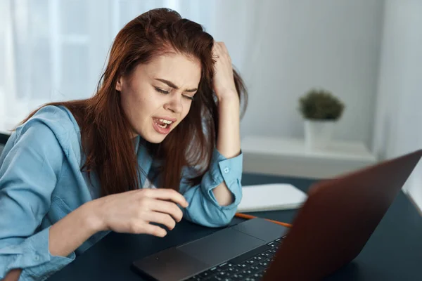 emotional woman in front of laptop at night work disorder