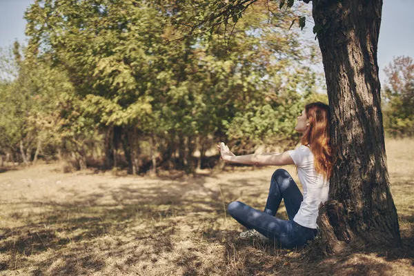 Kvinna sitter nära ett träd Sol frihet resa — Stockfoto