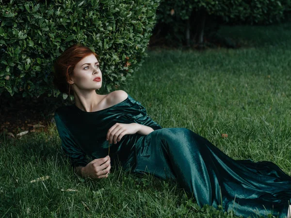 Μια γυναίκα σε ένα πράσινο φόρεμα βρίσκεται στον κήπο φύση το καλοκαίρι είναι μόδα — Φωτογραφία Αρχείου