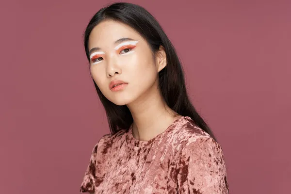 woman asian appearance bright cosmetics glamor pink background