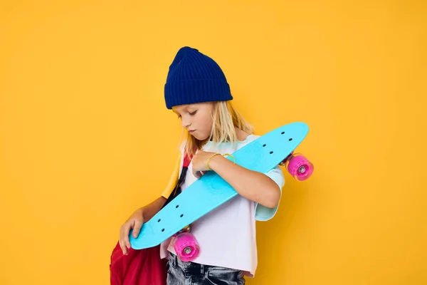 Teenager v bílém tričku pózující s skateboardem v ruce Dětství životní styl koncept — Stock fotografie
