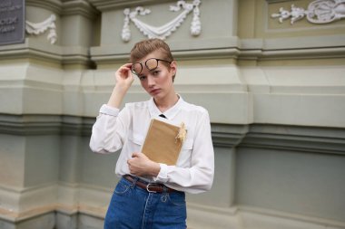 Elinde kitap olan güzel bir kadın açık havada eğitim okuyor.