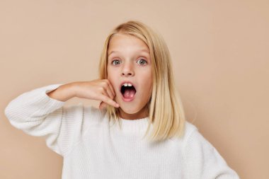 Süveter giyen küçük tatlı kız, stüdyo poz veriyor.