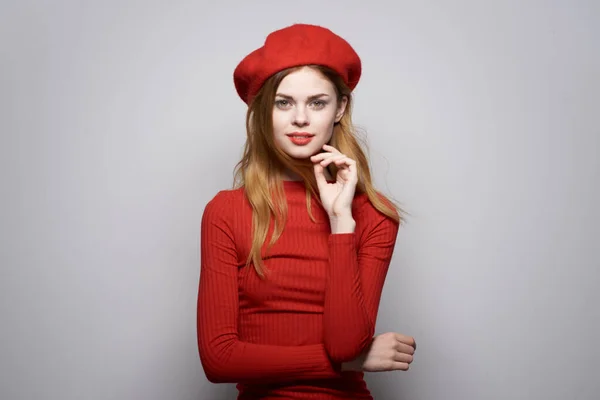 Όμορφη γυναίκα με ένα κόκκινο καπέλο στο κεφάλι του να ποζάρει στο στούντιο — Φωτογραφία Αρχείου