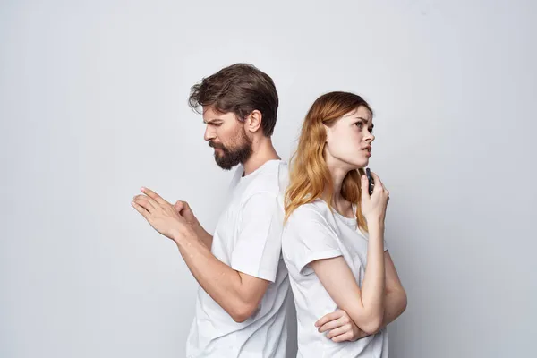 Coppia sposata in bianco T-shirt con i telefoni nelle loro mani studio stile di vita — Foto Stock