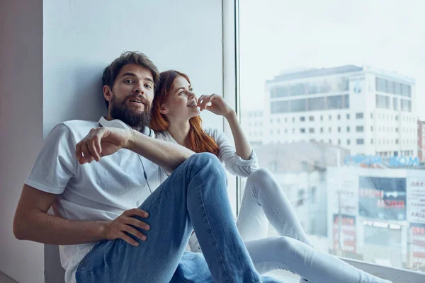 Мужчина и женщина сидят у окна с наушниками романтическая радость — стоковое фото