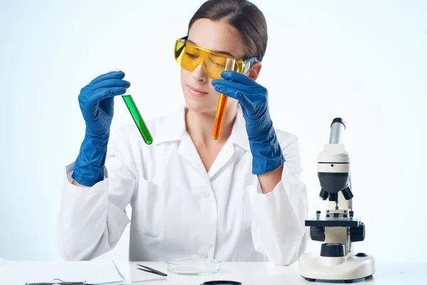 Laboratóriumi asszisztens kémiai megoldások biológus kutatás fény háttér — Stock Fotó