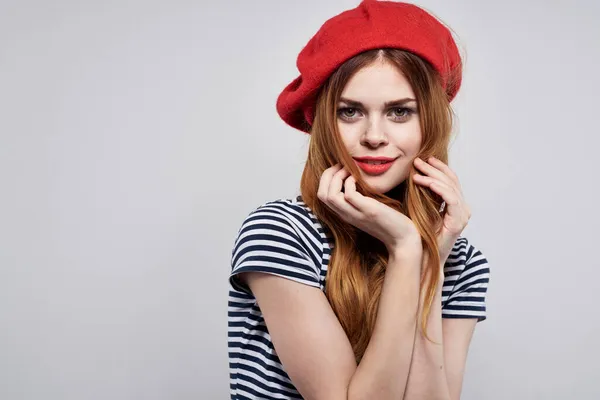 Bonita mujer con un sombrero rojo maquillaje Francia Europa moda posando fondo claro —  Fotos de Stock