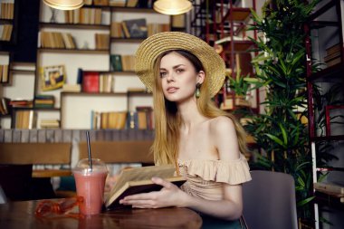 Kafe tarzında bir içkiyle masada oturan güzel bir kadın.
