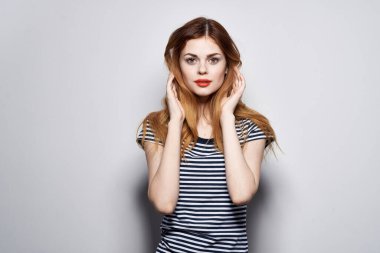 Çizgili tişörtlü güzel bir kadın, elleri izole edilmiş.