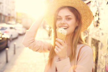 Çekici bir kadın açık havada yürüyor dondurma yiyor, şehir gezisi yapıyor.