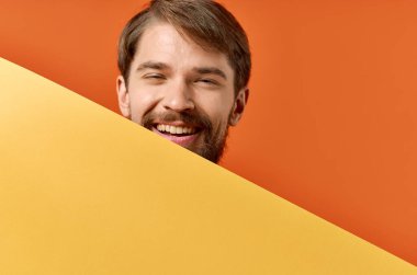 Sakallı adam reklam yapıyor. Fotokopi alanı turuncu arka planı.