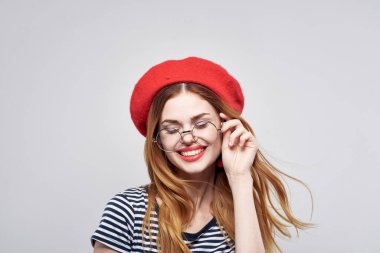 Kırmızı şapkalı neşeli kadın. Fransa Avrupa modası. Açık hava pozu veriyor.