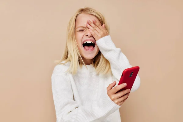 Щаслива мила дівчина спілкування смартфон розваги на бежевому фоні — стокове фото
