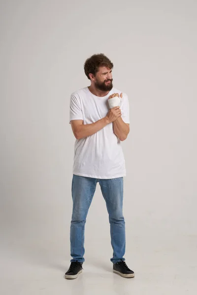 Homem barbudo em uma camiseta branca com uma mão enfaixada posando fundo isolado — Fotografia de Stock