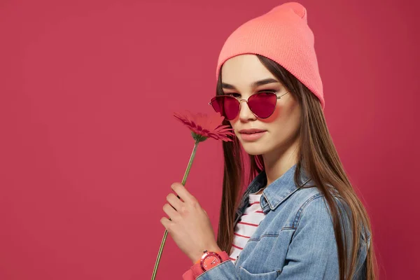 Kobieta nosi okulary przeciwsłoneczne kapelusz pozowanie moda różowy tło — Zdjęcie stockowe