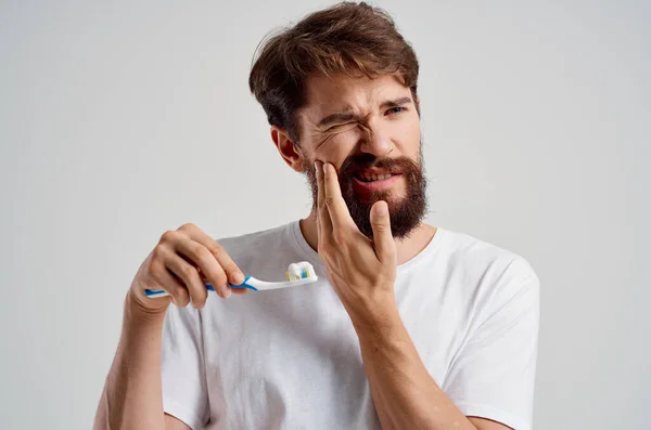 Barbuto uomo igiene dentifricio mattina luce sfondo — Foto Stock
