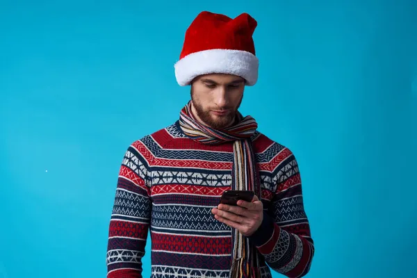 Elinde telefon olan, Noel Baba şapkalı neşeli bir adam. — Stok fotoğraf