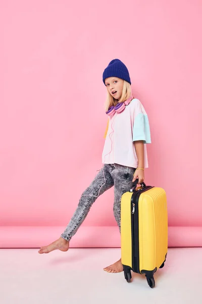 예쁜 여자파란 모자노란 여행 가방 포즈를 취하는 여자 — 스톡 사진