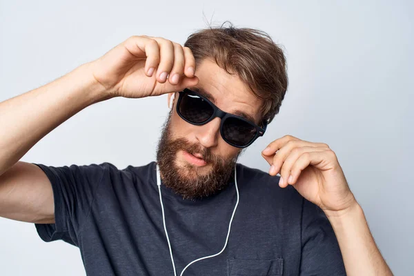 Knappe man draagt bril luisteren naar muziek op hoofdtelefoon geïsoleerde achtergrond — Stockfoto