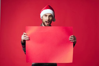 Yakışıklı bir adam Noel 'de kırmızı bir maket posteriyle izole edilmiş.