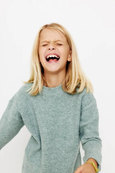 Portrét usměvavé roztomilky ve svetru, grimasy pózující studio — Stock fotografie