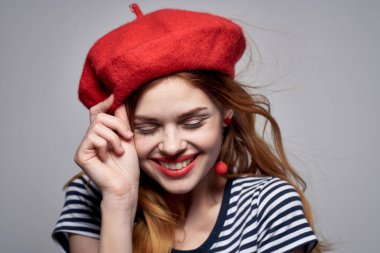 Kırmızı şapka takan neşeli kadın Fransa Avrupa tarzı poz veriyor.