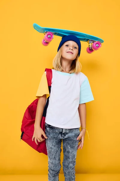 Skolflicka glad söt barn med skateboard unge med ryggsäck isolerad bakgrund — Stockfoto