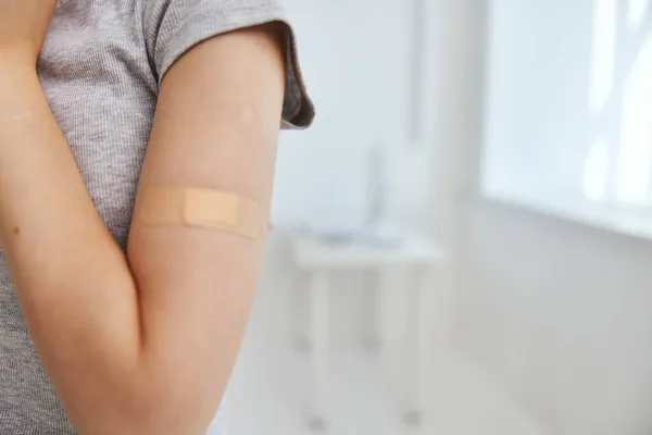 Kvinna med gips på armen covid-19 vaccination — Stockfoto