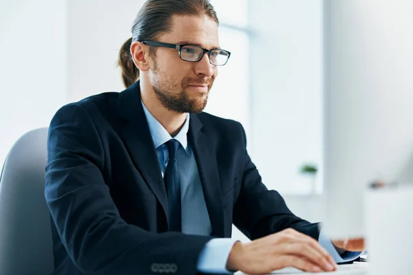 Homme d'affaires avec des lunettes dans un costume travaille à l'ordinateur dans le bureau — Photo